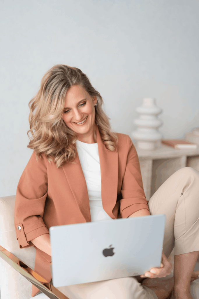 Doreen von La Webista sitzt entspannt im Sessel und arbeitet mit sichtbarer Freude an einer Website auf ihrem Laptop